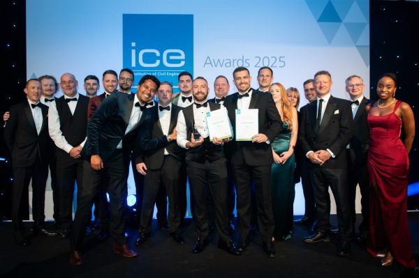 Members of the team from WECA, BAM Nuttall, BTQ LLP and Network Rail stand on stage wearing black tie dress, holding an award. Behind them a sign says ICE awards 2025.